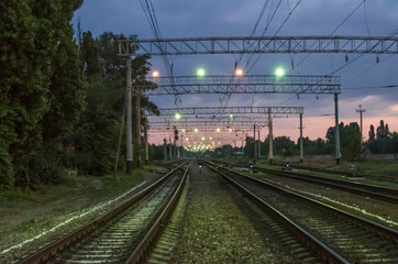 Fototapeta na wymiar A railway illuminated by multicolored lights at dawn