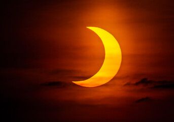 Partial solar eclipse with bright reddish glow