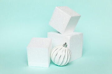Simply minimal composition winter object ornament and cube shapes geometric form podium isolated blue pastel background. Christmas New Year december time for celebration concept. Mockup, copy space