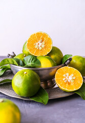 Mapo fruits in the tin bawl and plate on grey background 