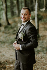 The groom on his wedding day in a black suit.