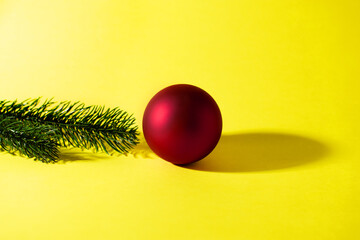 Red decorative christmas ball on yellow background
