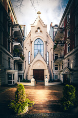 Fototapeta na wymiar Hamburg church between residential buildings, a facade like in New York. Catholic Apostolic Church Finkenau.