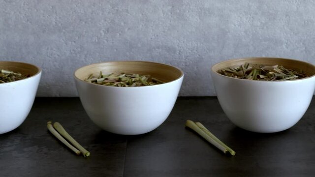 Bowls with cut lemon grass drying. Organic herb. Camera slide.