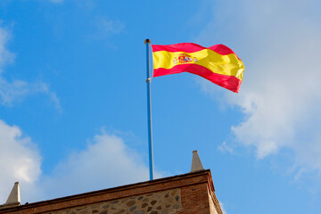 Spanish flag waving in the wind outside in Toledo, Castille-La-Mancha, Spain