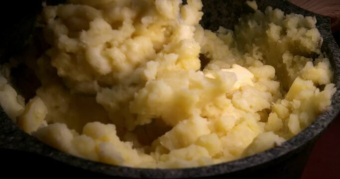 Make mashed potatoes close up at potato bowl.