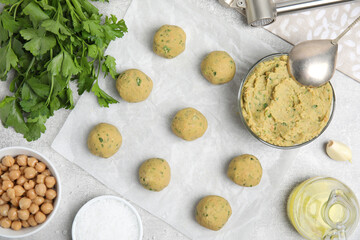 Raw falafel balls and ingredients on grey table, flat lay