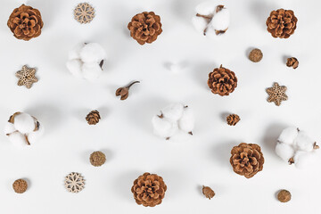 Winter arrangement with fir cones, snowflake ornaments and cotton Gossypium on white background