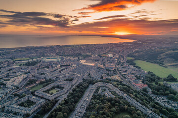 Aerial view of Edinburgh in the morning. Rising above the horizon, the sun radiates its warmth onto the city, highlighting all of its beautiful sights.  Great view on top Arthur's Seat morning sunrise