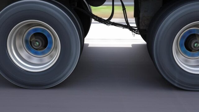 Passing commercial truck or lorry. Detail of wheels with blue hubs. Highway driving in Ontario, Canada.