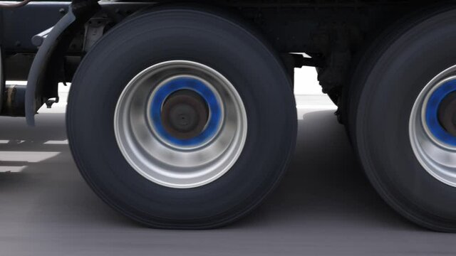 Overtaking commercial truck or lorry. Detail of wheels with blue hubs. Highway driving in Ontario, Canada.