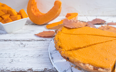 Pumpkin pie slices with cinnamon and pumpkin on a white wooden background, top view. Homemade cakes for a traditional pumpkin pie for Thanksgiving, Halloween.