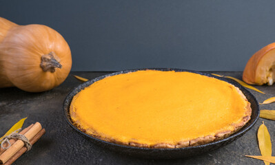 Traditional autumn dishes. Halloween, Thanksgiving. Spicy American Pumpkin Pie, on black with gold stone table.