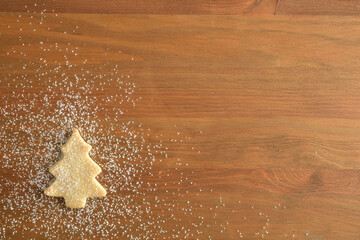 Christmas background with fir cookie with icing sugar on wooden