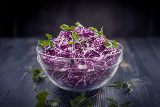 Purple cabbage. Red cabbage and parsley salad, on dark wooden background