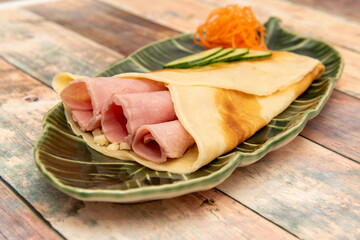 Salty French crepe filled with cooked ham, cheese and sliced fresh vegetables