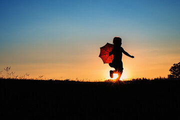 A Sunset Silhouette with a Girl Child Kid Running with a Red Umbrella Blue Orange Gorgeous Sun...