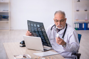 Old male doctor radiologist working at the hospital