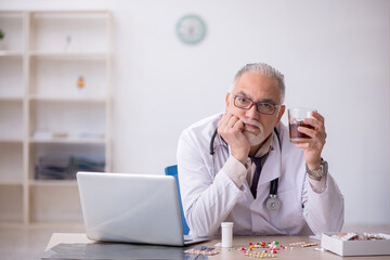 Old male doctor working at the hospital