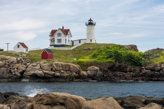 Cape Neddick Lighthouse, Nubble Light, at York Maine, New England, USA
 Horizontal Photo, Photograph, the white historic lighthouse, keepers house is white with red roof is on tall, small island blue