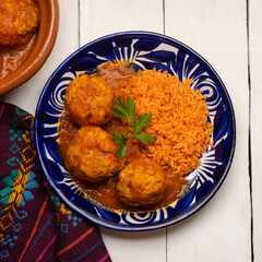 meatballs with red rice and tomato broth on a white background. Mexican food