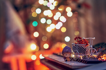 A toy bike and a christmas elf on a musical synthesizer. Helper to Santa Claus. Dried branches of...