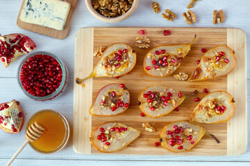 Pears baked with gorgonzola cheese sprinkled with pomegranate seeds
