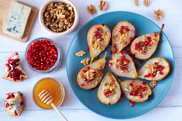 Pears baked with gorgonzola cheese sprinkled with pomegranate seeds