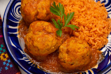 meatballs with red rice and tomato broth on a white background. Mexican food