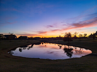 Obraz premium Sunset view of a community lake and residence