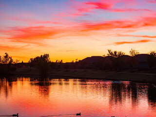 Sunset view of a community lake and residence