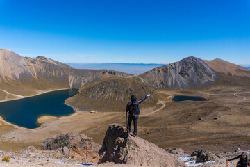 Young hiker backpacker female on the cliff edge and enjoying peak view