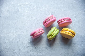 Multicolored macarons on a gray background.