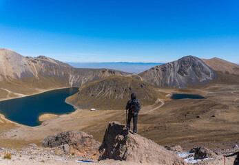 Fototapeta na wymiar Young hiker backpacker female on the cliff edge and enjoying peak view
