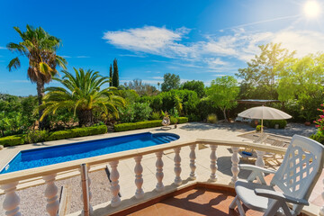 Luxurious house with a terrace, in a classic style with columns and a swimming pool. Luxurious courtyard with pool and garden with palm trees.