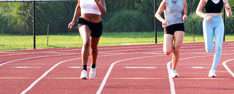 Three college women training by running on a red track © coachwood
