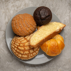 Basket with Mexican sweet breads on a gray background.