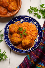 meatballs with red rice and tomato broth on a white background. Mexican food