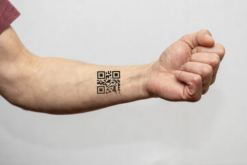 The hand of an elderly man with a tattooed QR code on a light background. Concept: assigning QR codes to people with antibodies to the species, Vaccination against coronavirus, antigen test, 