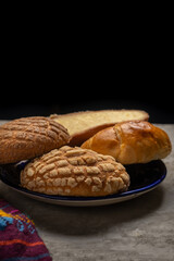 Basket with Mexican sweet breads on a gray background.