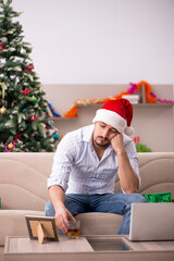 Fototapeta premium Young man celebrating Christmas at home alone