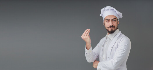 Amazed young male Italian handsome chef. He is Gesturing delicious sign, studio shot includes copy...