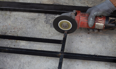 Close up, A man working with angle grinder. Iron gate repair