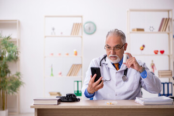 Old male doctor working in the clinic