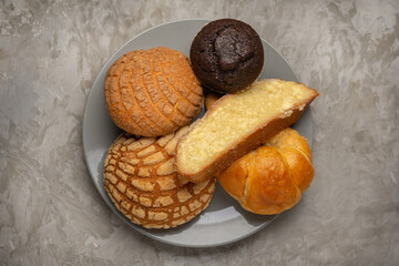 Basket with Mexican sweet breads on a gray background.