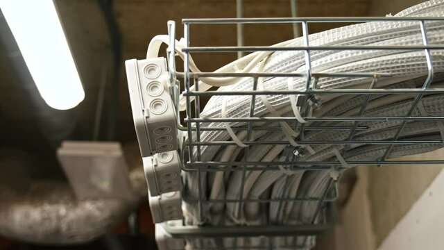 Electrical Box Power Cables and Telecommunication Wiring Tied in Basket Hanging Under Ceiling in Residential Building Basement