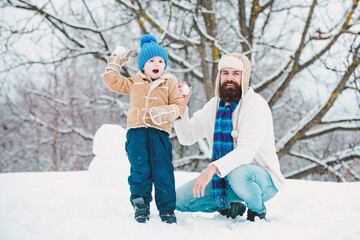 Winter, father and son play outdoor. Father and son play with snowball on winter white background. Christmas holidays with father.
