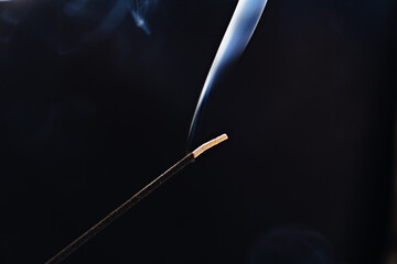 smoke from an aromatic stick on a black background.