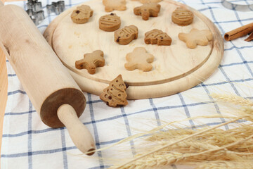 Homemade Christmas ginger bread cookies, Xmas gingerbread cookie on wooden tray with rolling pin, preparing bakery, process of baking and cooking at home