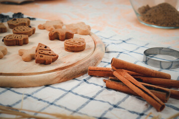 Homemade Christmas ginger bread cookies on wooden try with cinnamon, Xmas gingerbread cookie, preparing bakery, process of baking and cooking at home.